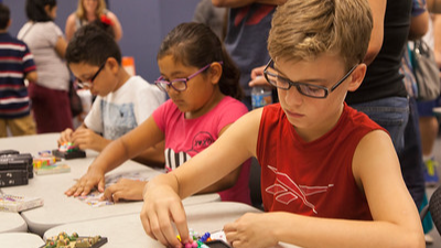 three elementary students working puzzles