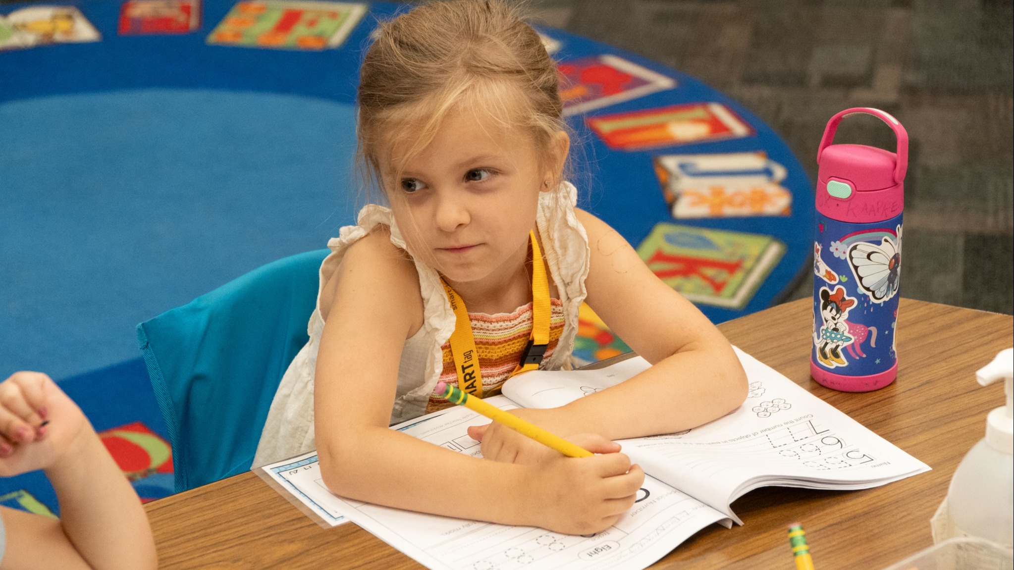 student sitting at desk witing in a workbook