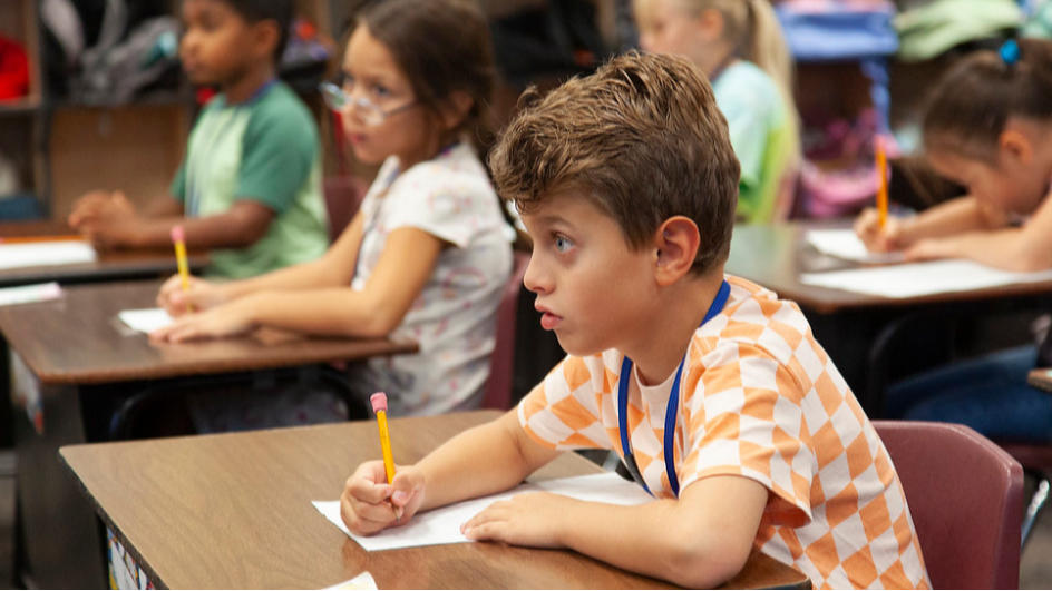 three stluldents working in a classroom