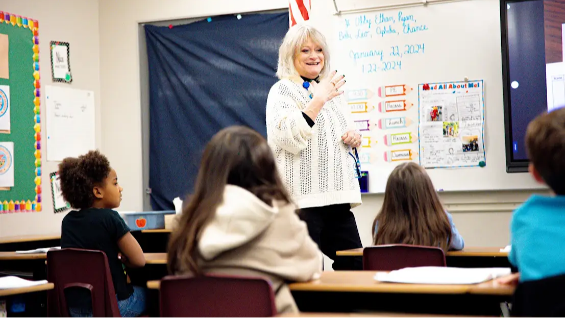 teacher standing in front of class showing flashcards