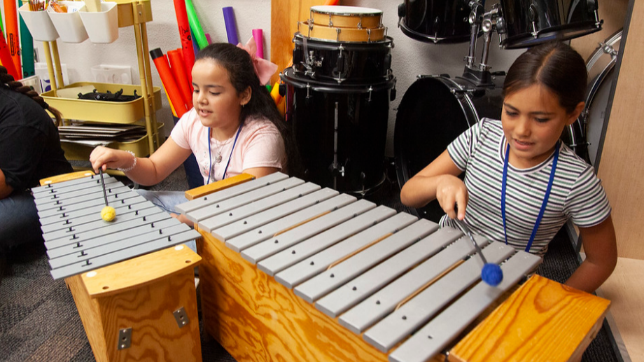 two students playing xylophone