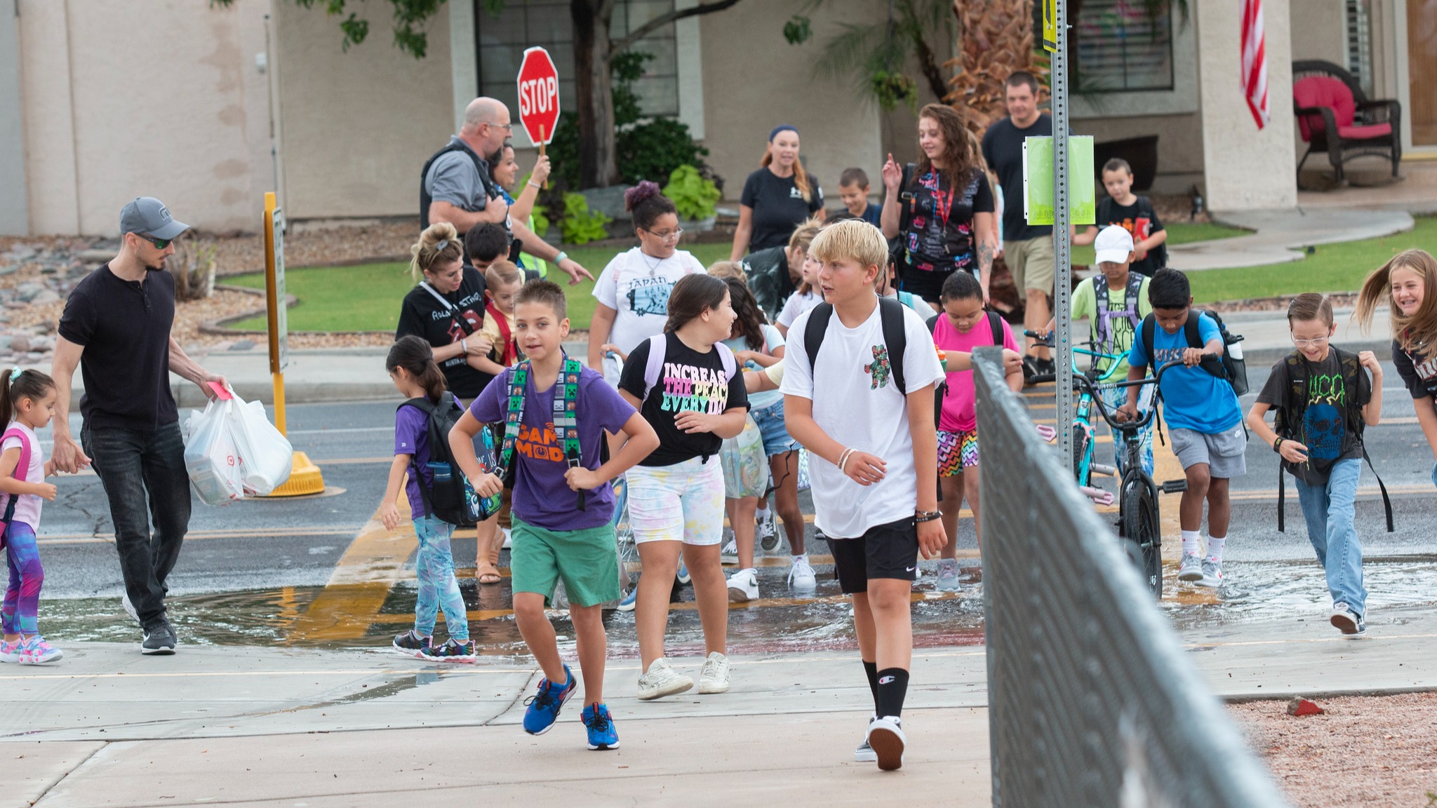 students crossing in cross walk and walkint towards the school