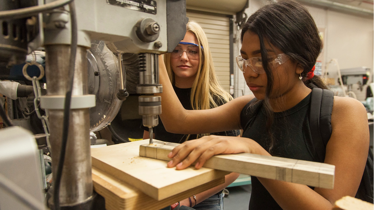 two students drilling into a piece of wood