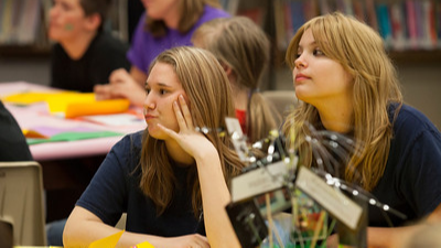 two students sitting at a table looking forward