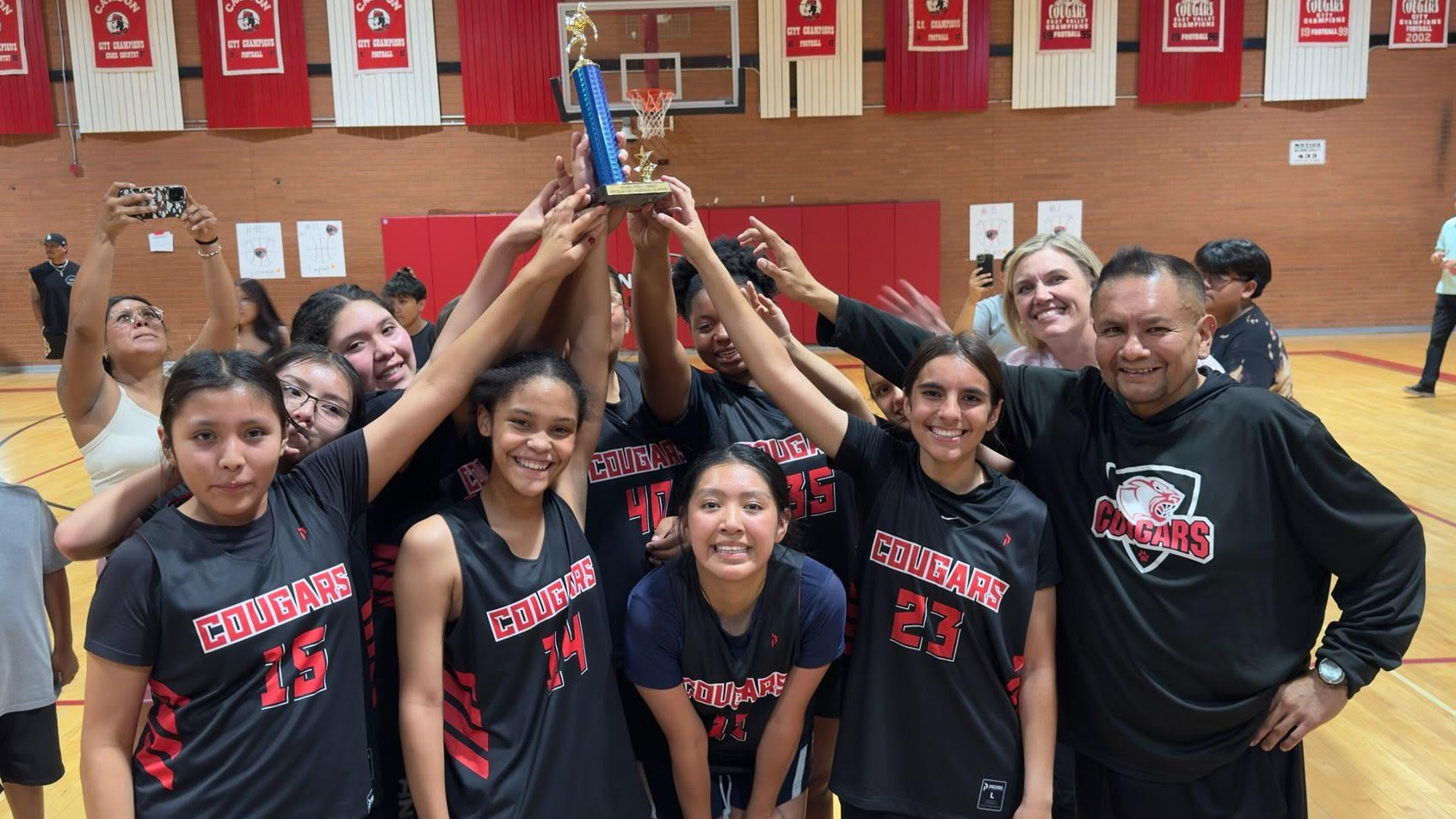 girls basketball team holding up a torphy