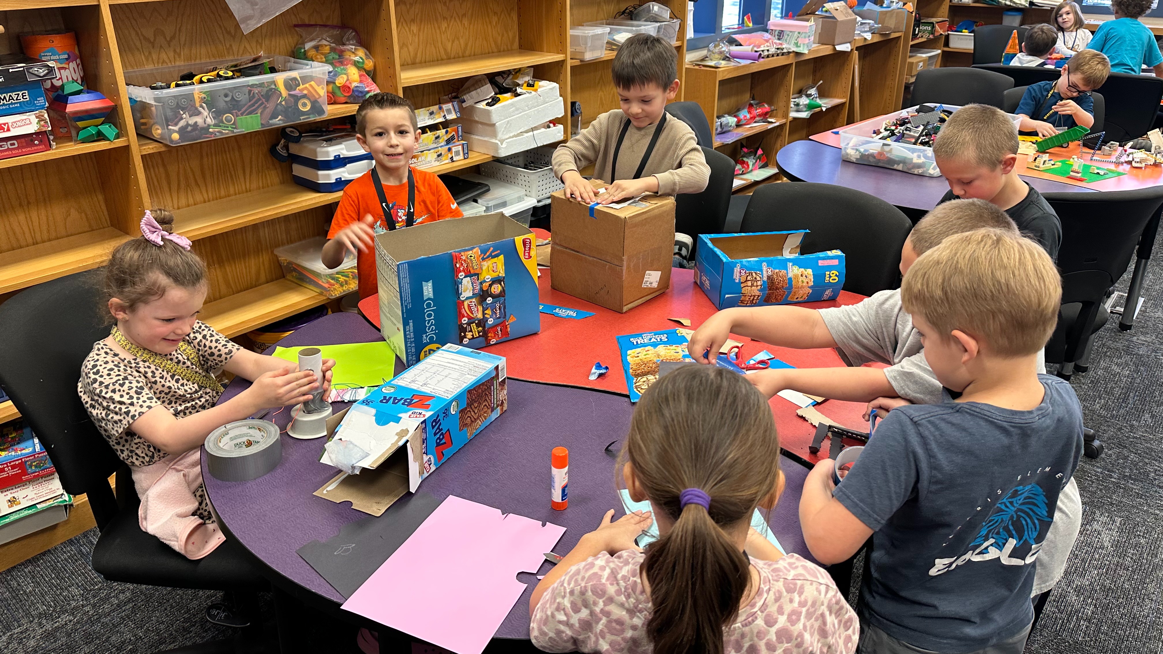 five students creating things at a makerspace table