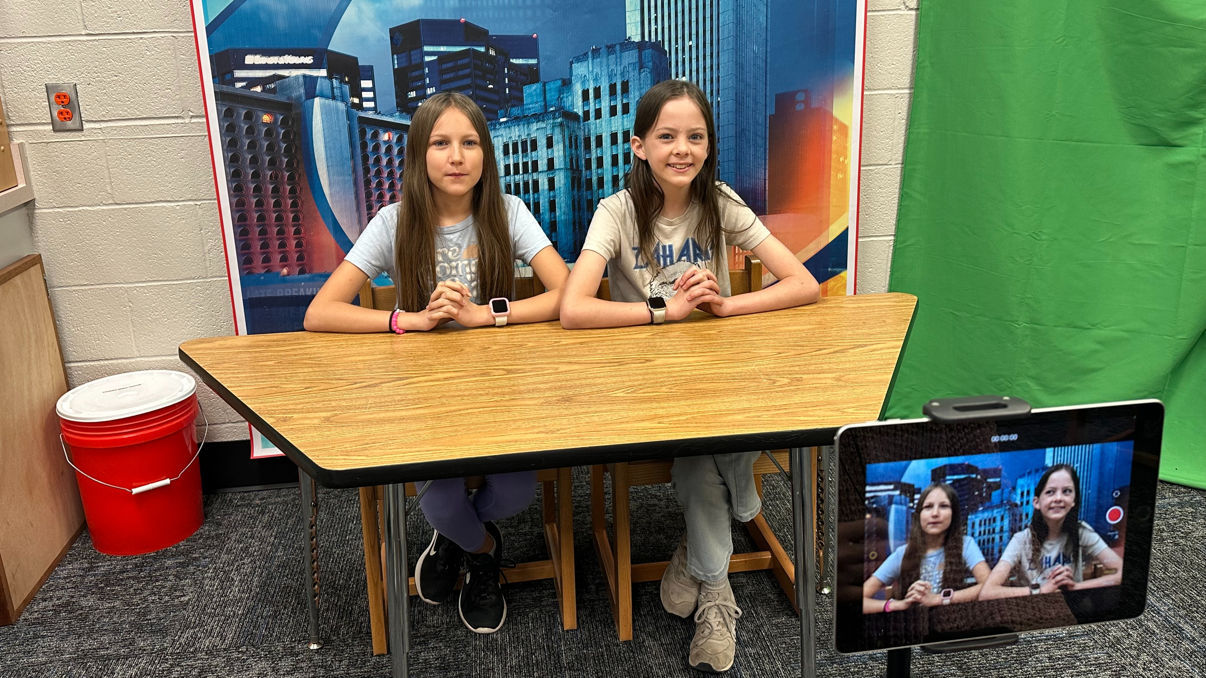 two students sitting at a broadcast table