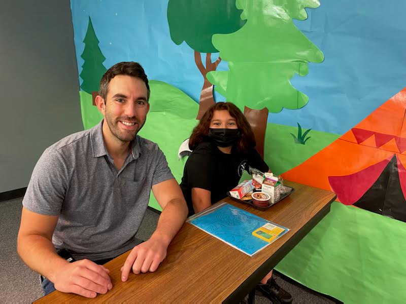 Counselor smiling at a table with a student