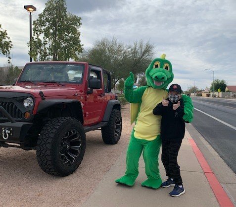 Dragon mascot taking a picture with a student