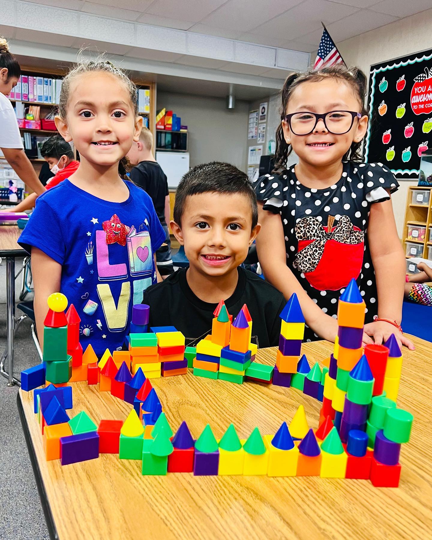 primary students standing in front of colored wood blocks set up like a castle