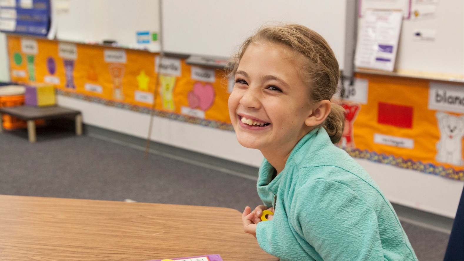 Student sitting at a desk and smilig