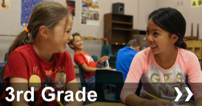 3rd grade 2 students with pencils looking at each other