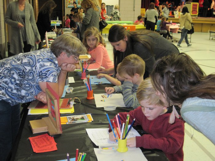students practice using montessori materials at family math night