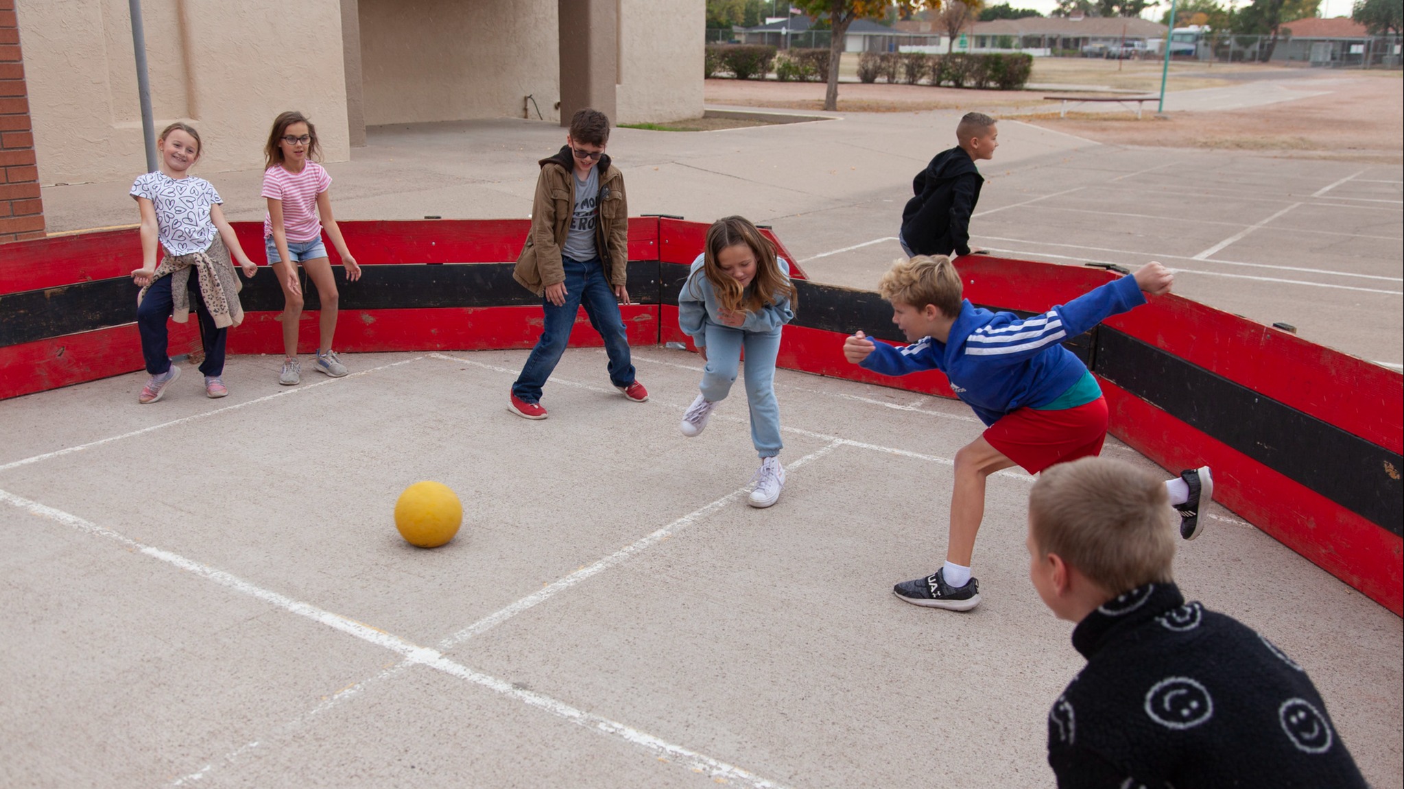seven stulldents in a circle playing with a ball