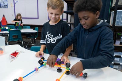 two students building something with connecting blocks