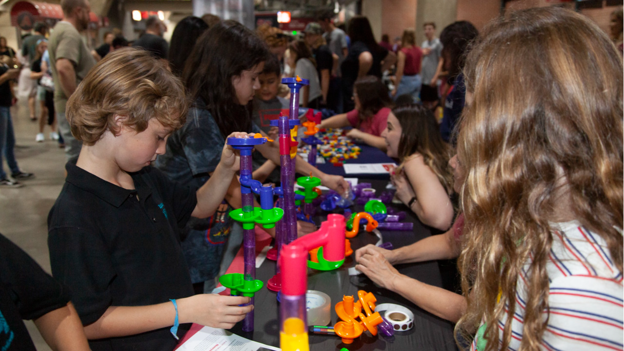 students at a table building with bright colored connecting pieces