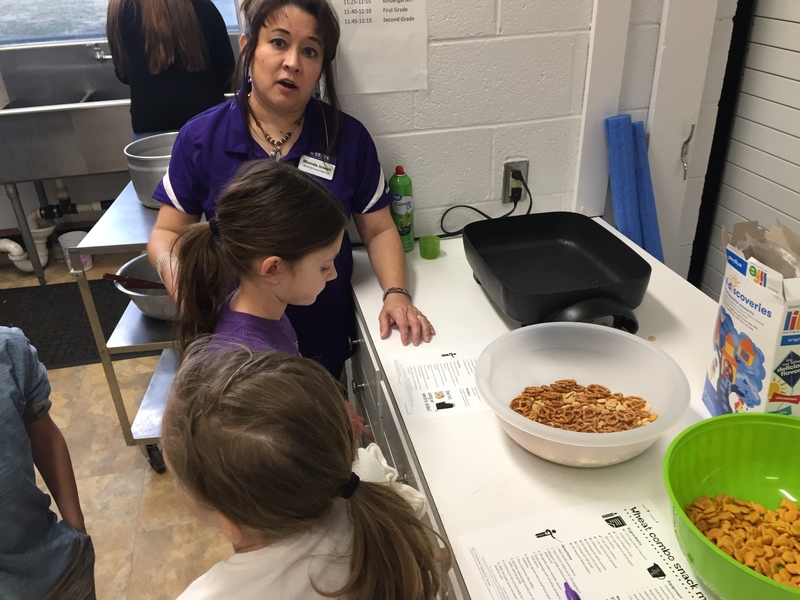 A photo of students making healthy snacks with their teacher