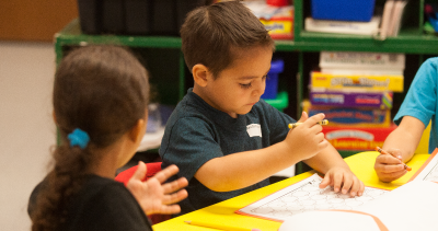 two students coloring with crayons