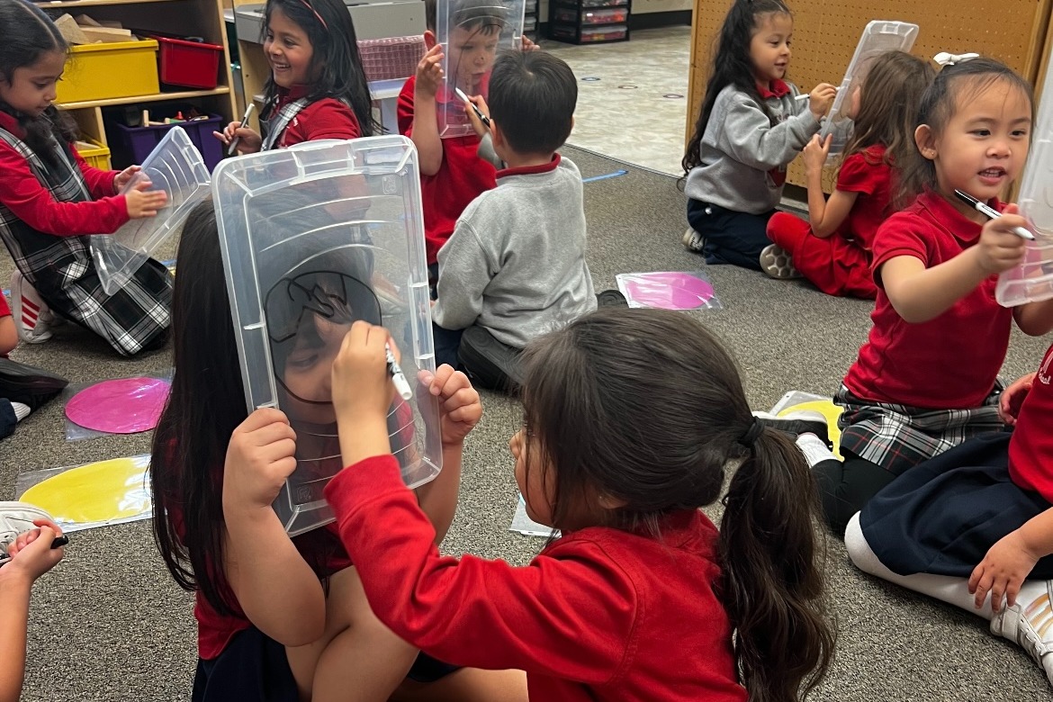 Drawing classmates' facial features while working on fine motor skills.