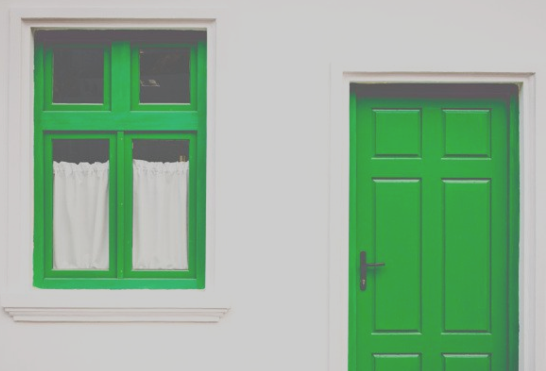 A photo of a house with green door and window