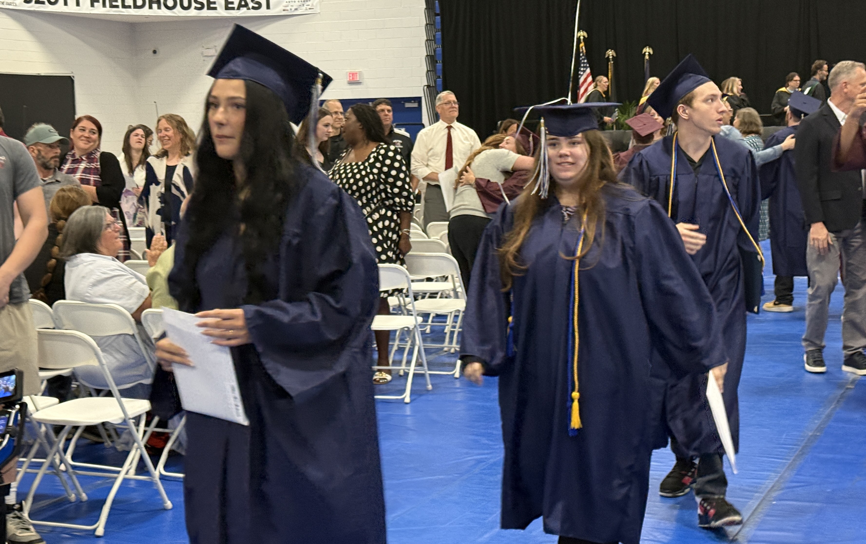 Students walking at graduation in cap & gown