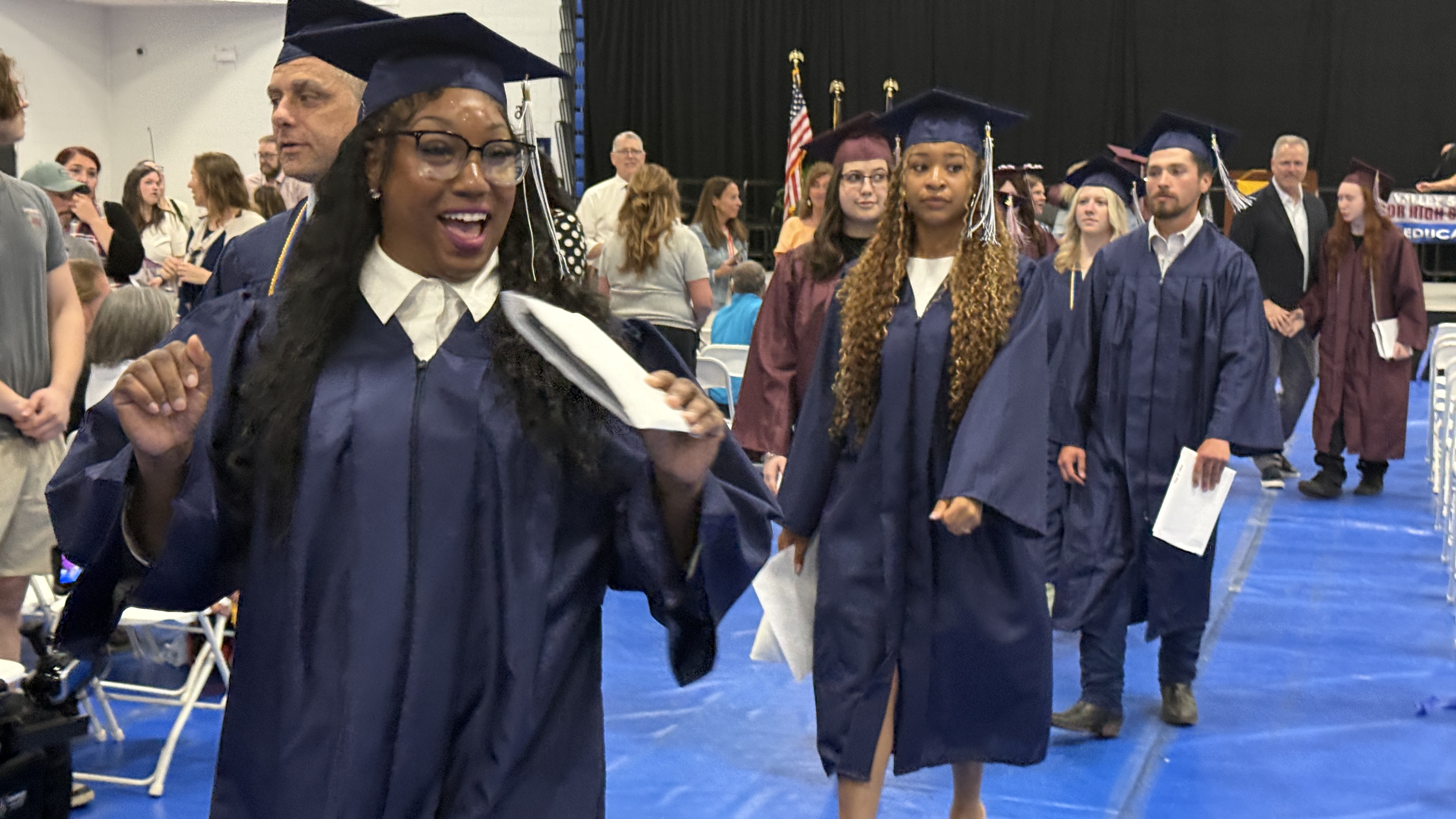 Students walking at graduation in cap & gown