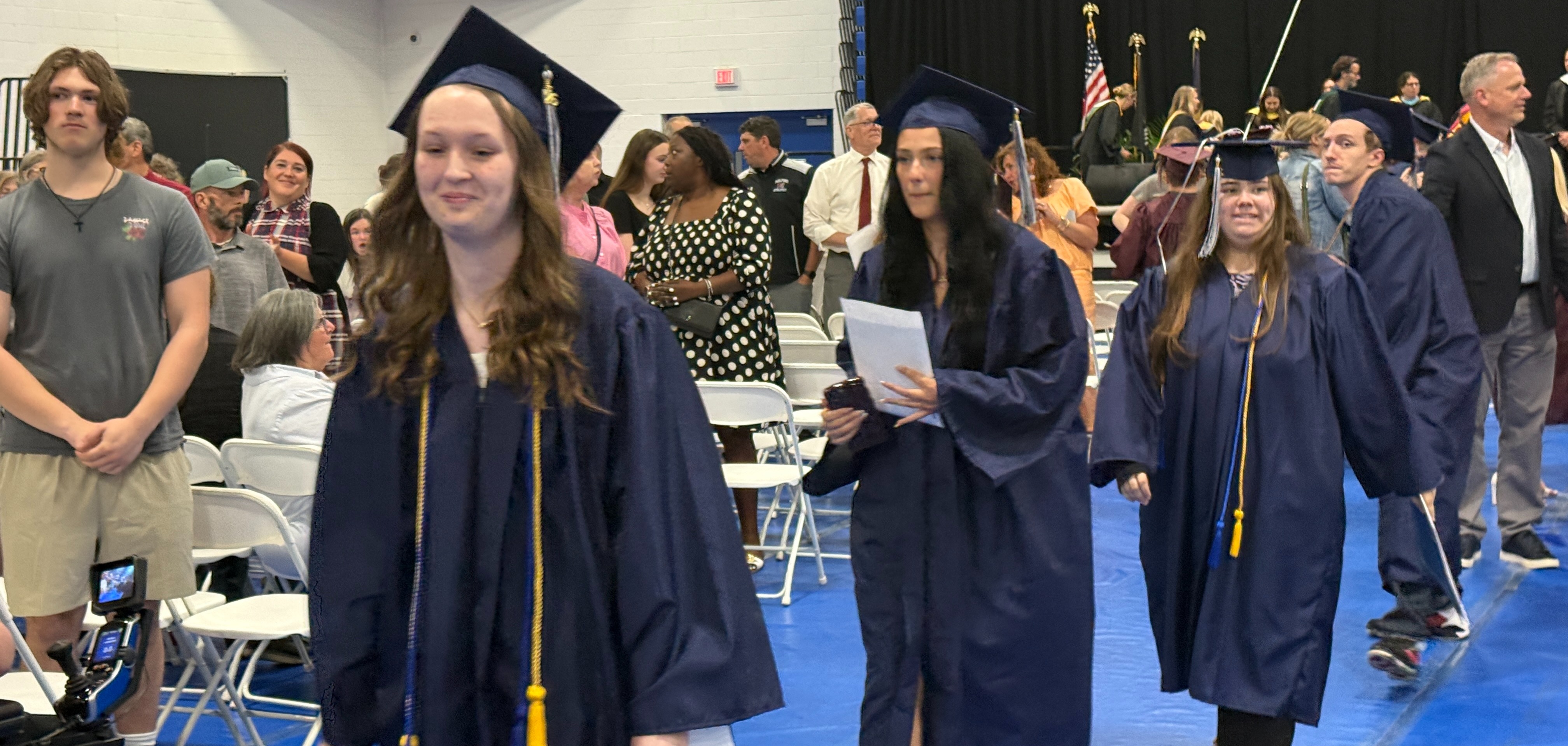 Students in cap & gown walking at graduation