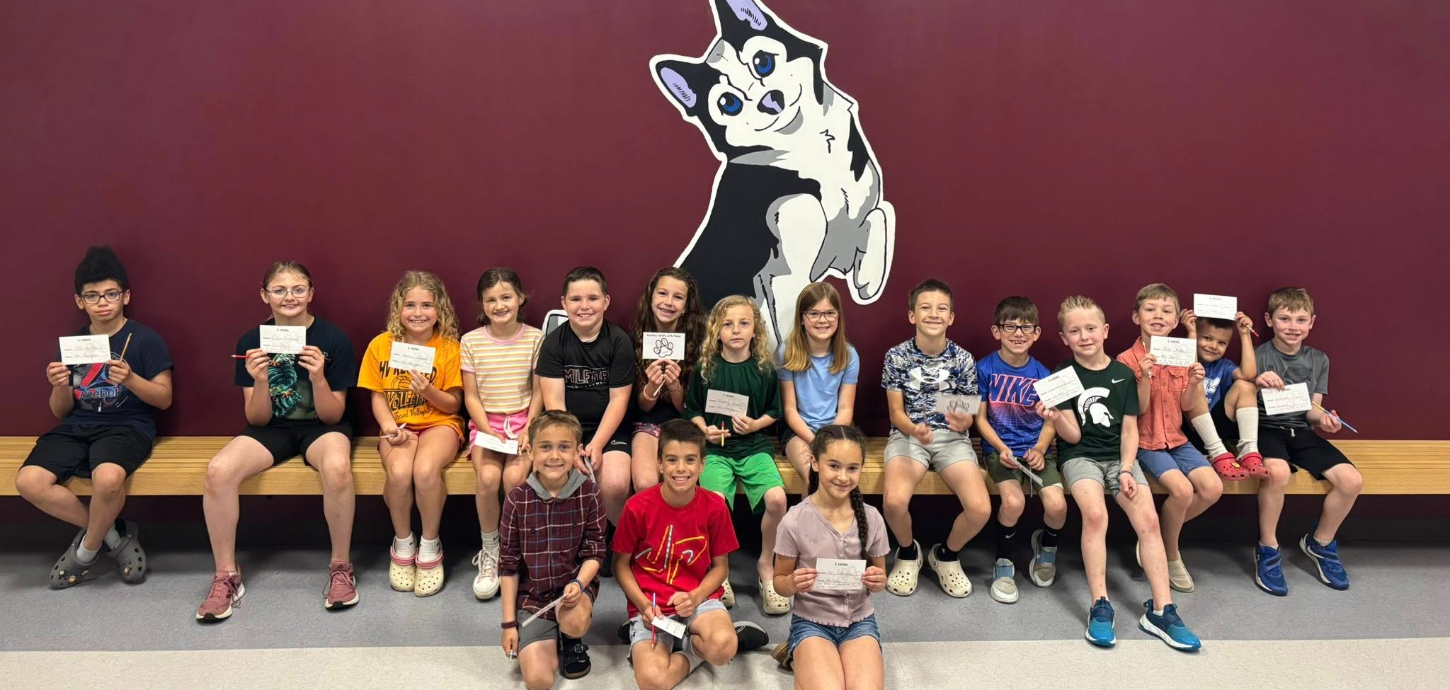 Group of students in front of Huskie mascot painting