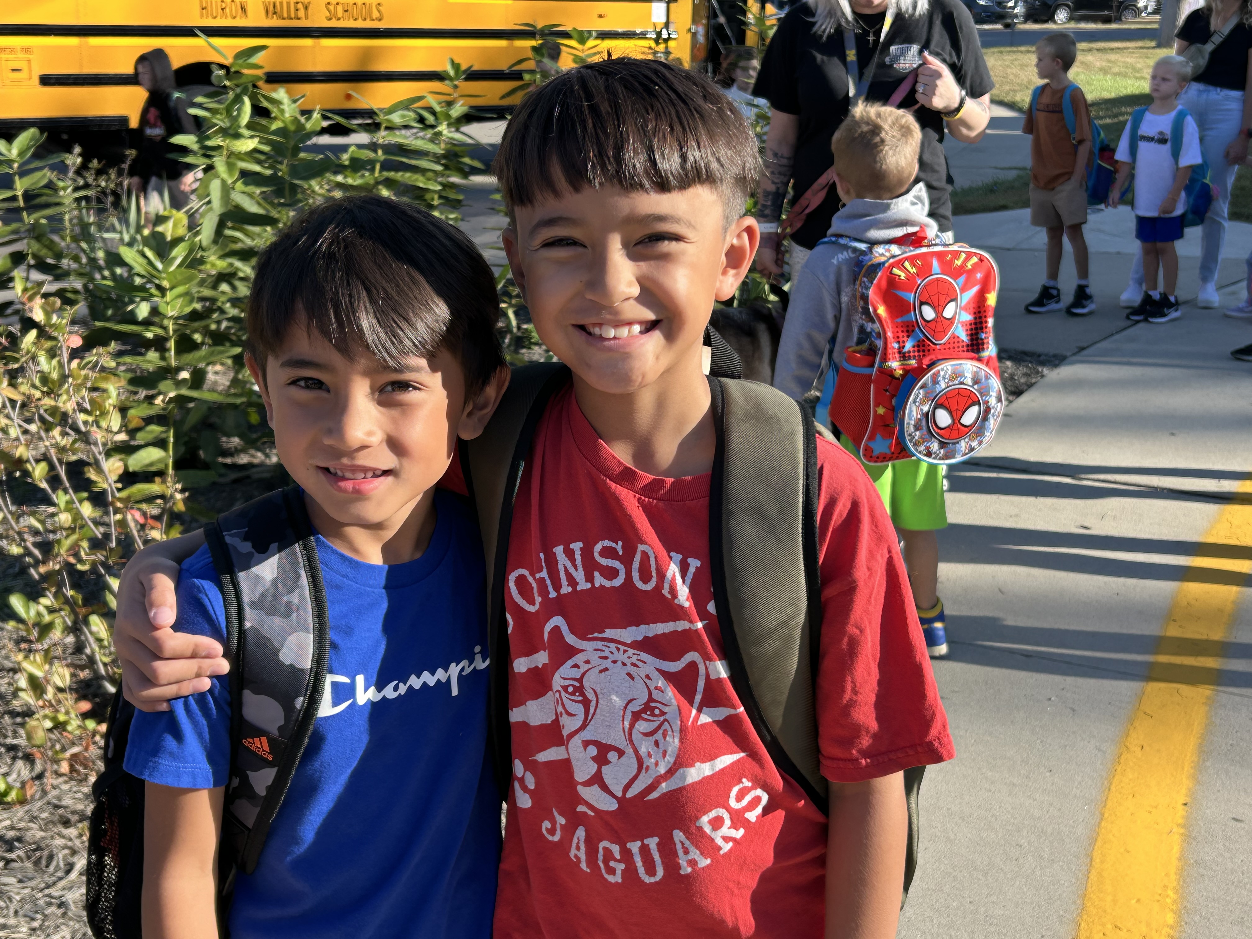 Two students hugging, smiling and posing for a picture