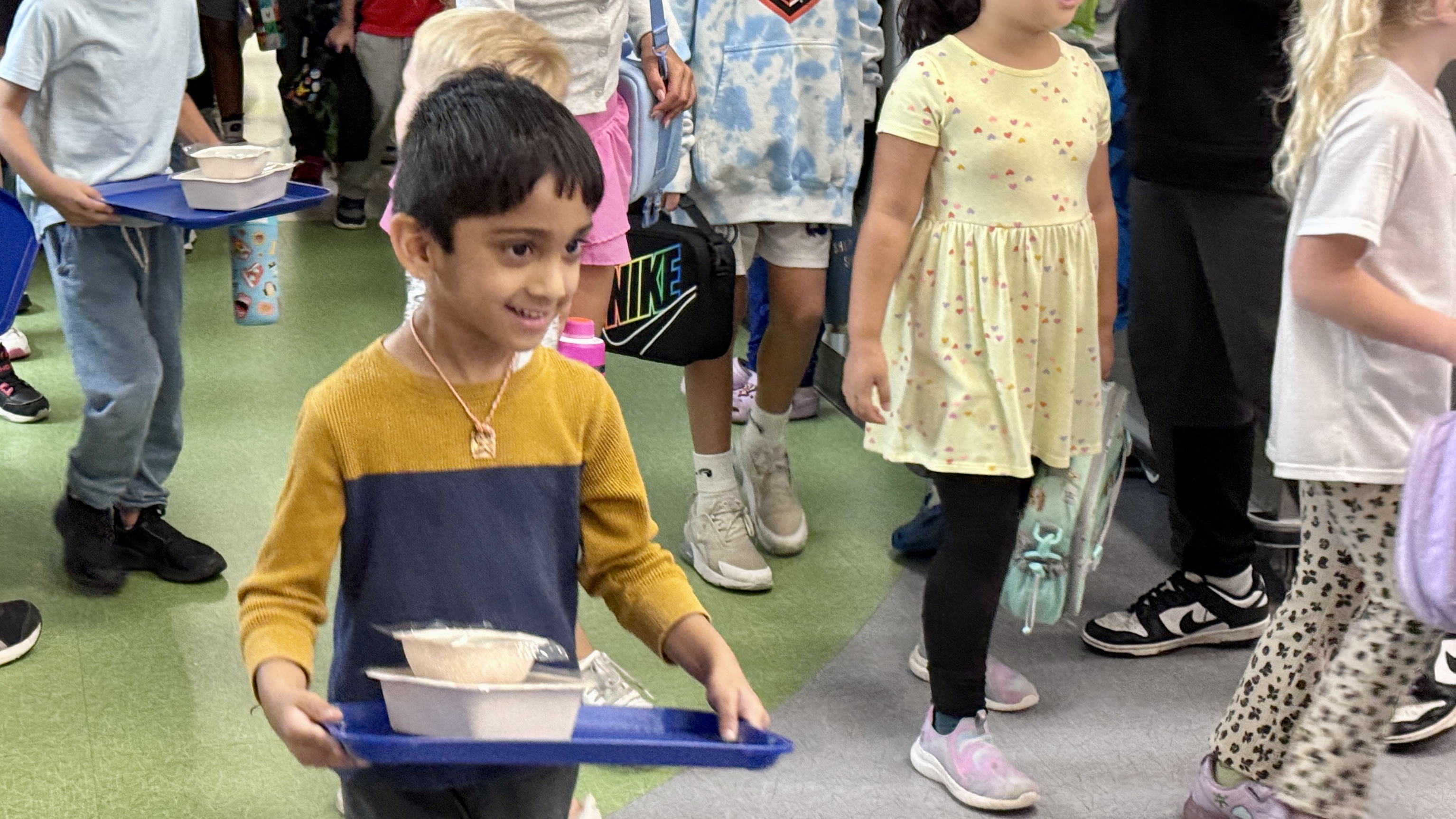 photo of student carrying food tray in lunch room