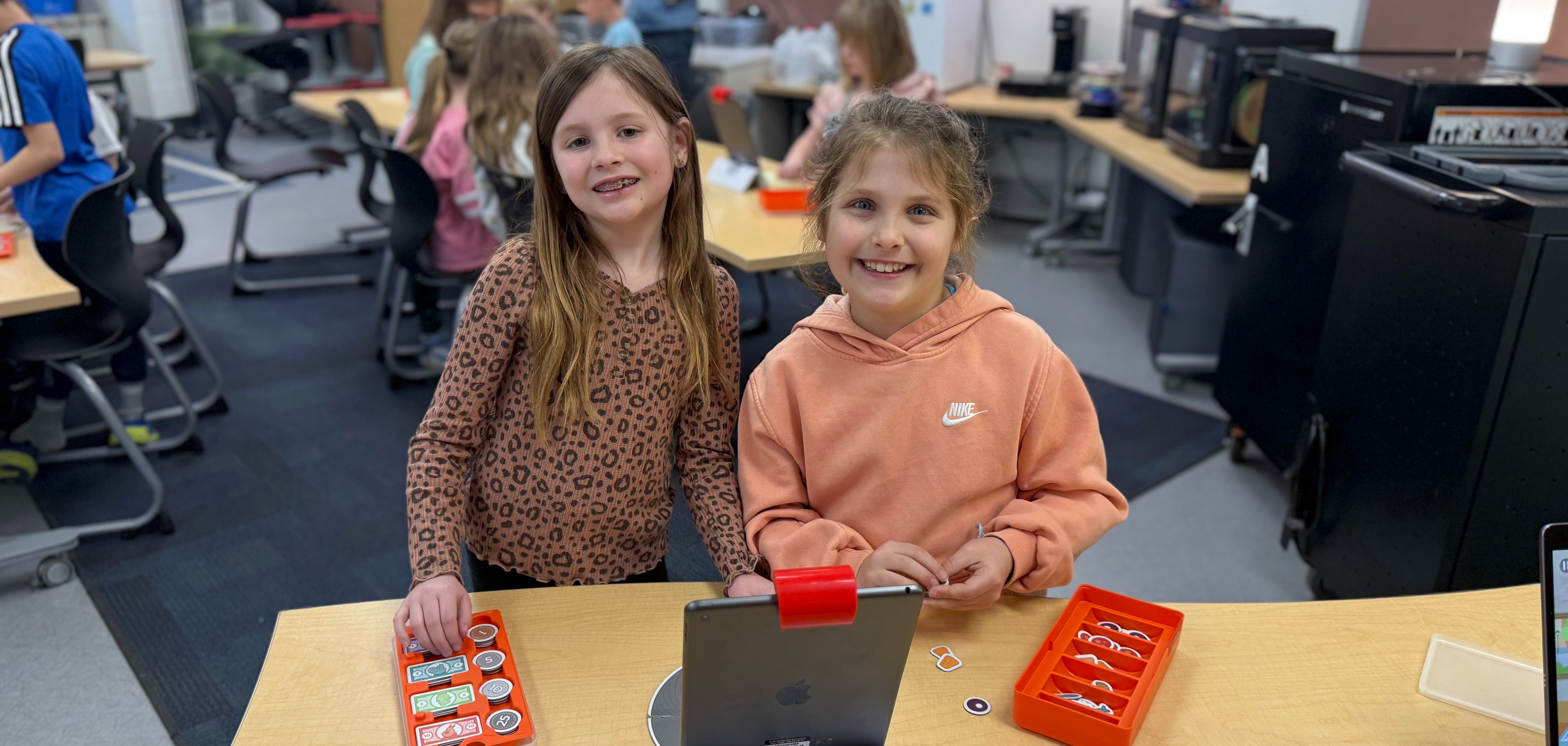Students playing an OSMO pizza game in technology.