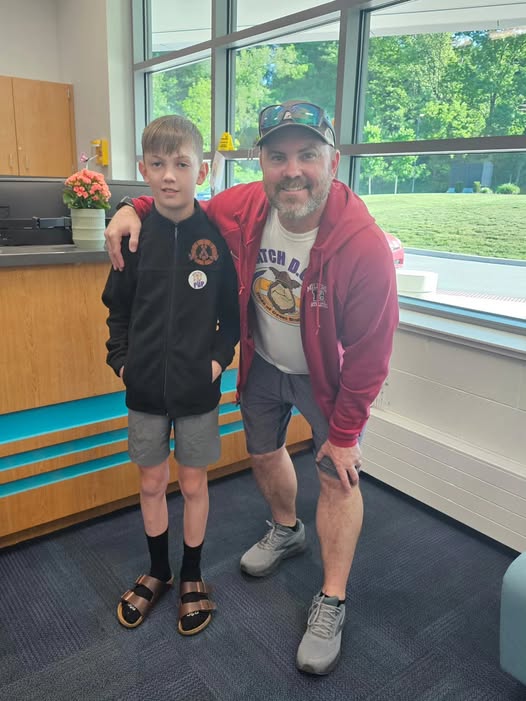 Adult posing with student in school office for the watch d.o.g.s. program