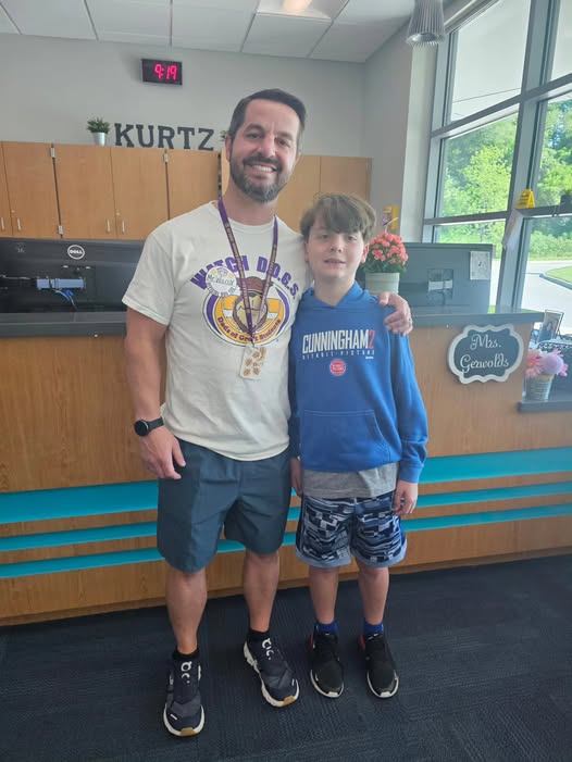 Adult posing with student in school office for the watch d.o.g.s. program