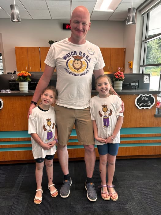 Adult posing with student in school office for the watch d.o.g.s. program