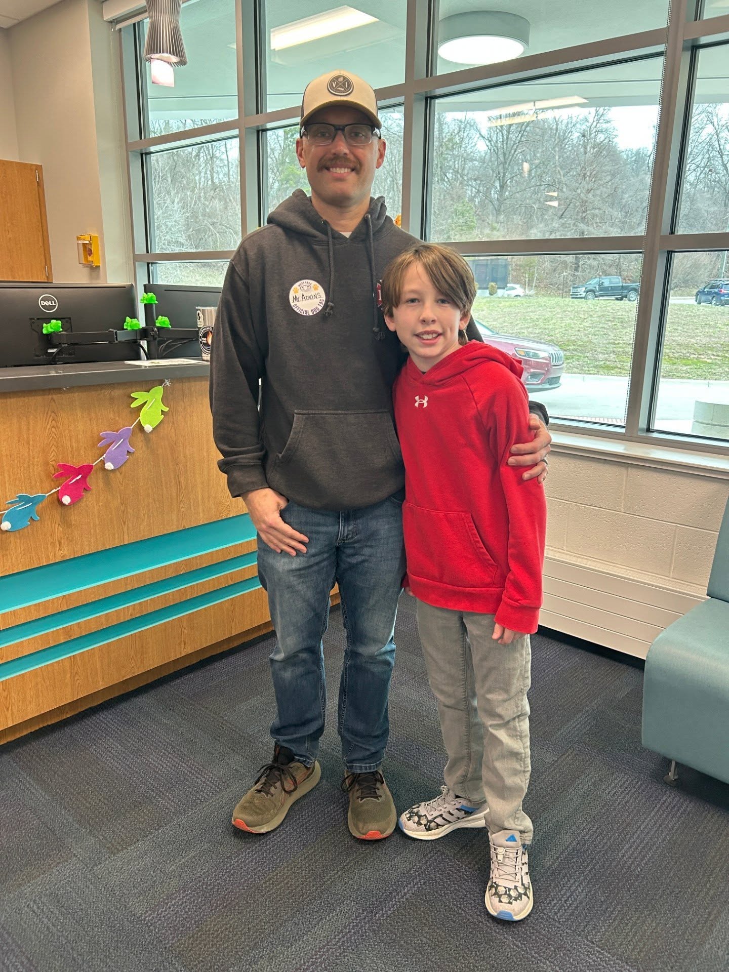 Adult posing with student in school office for the watch d.o.g.s. program
