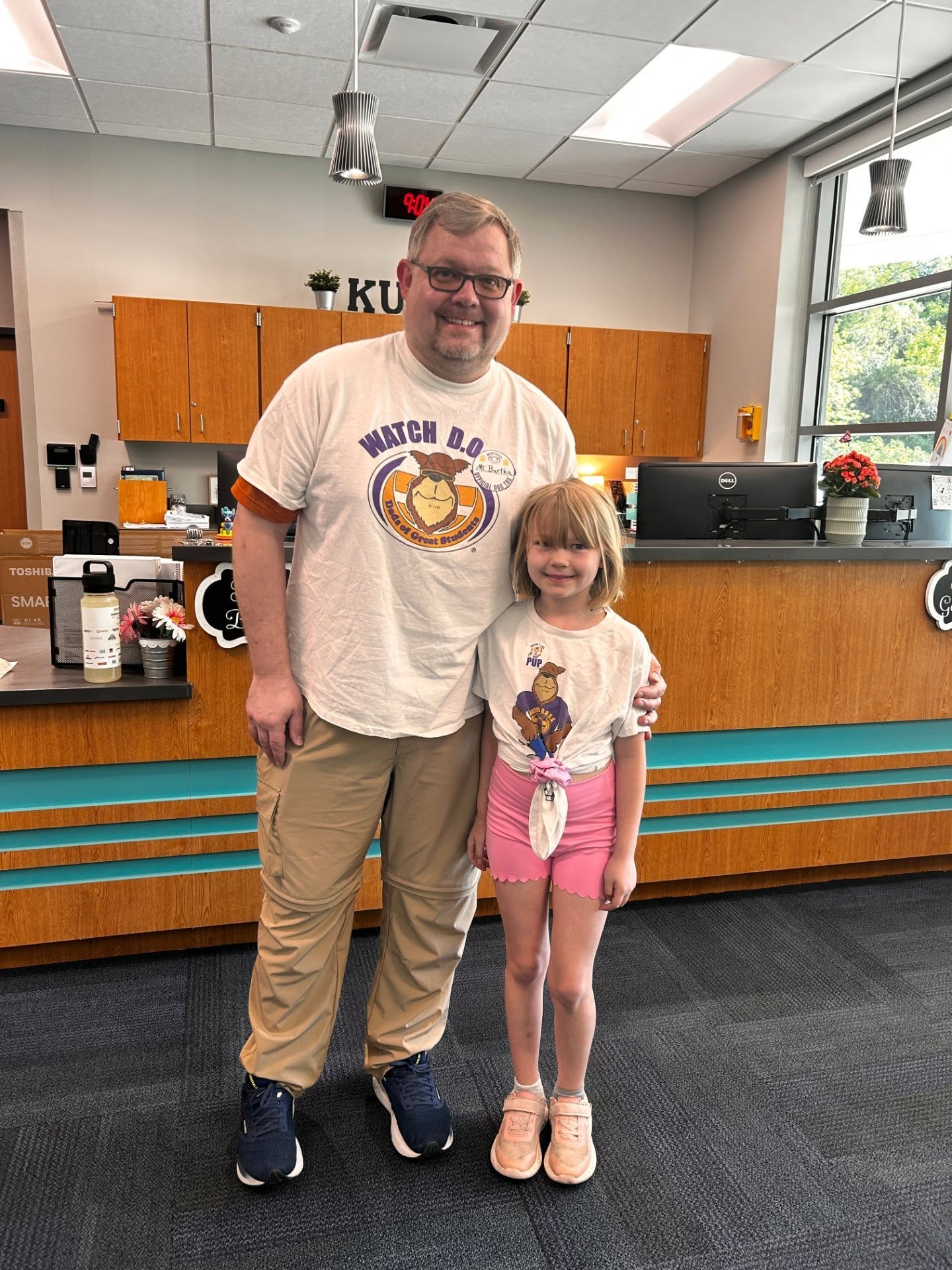 Adult posing with student in school office for the watch d.o.g.s. program