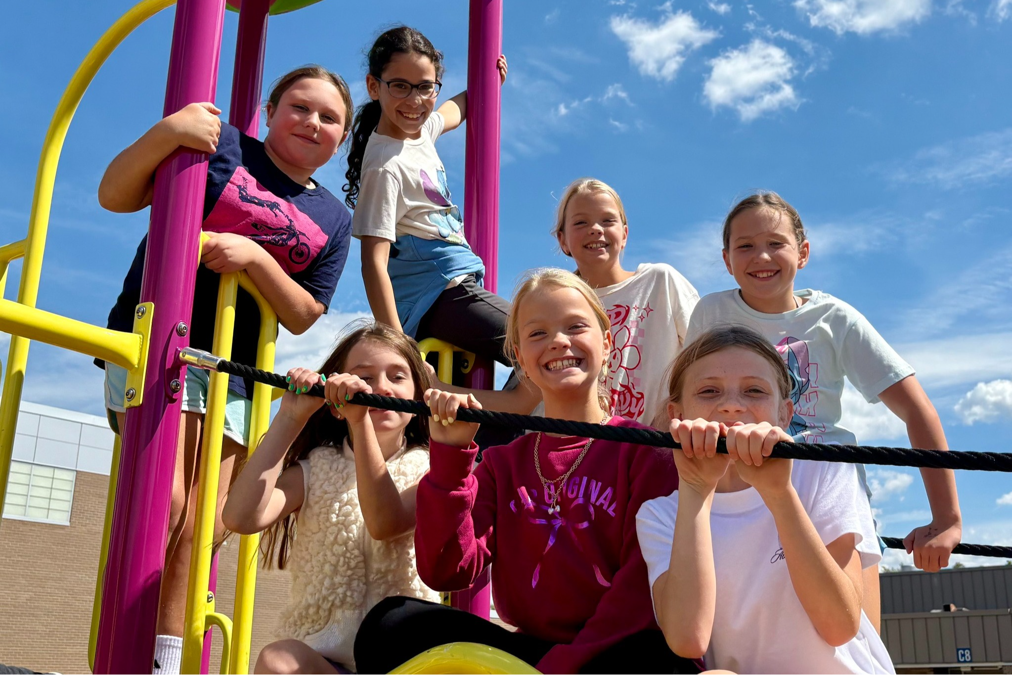 Students on a play structure outside