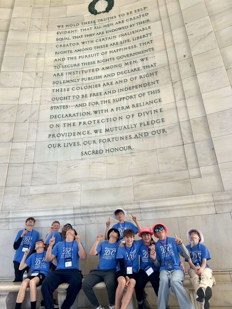 students pose for photo at monument in DC