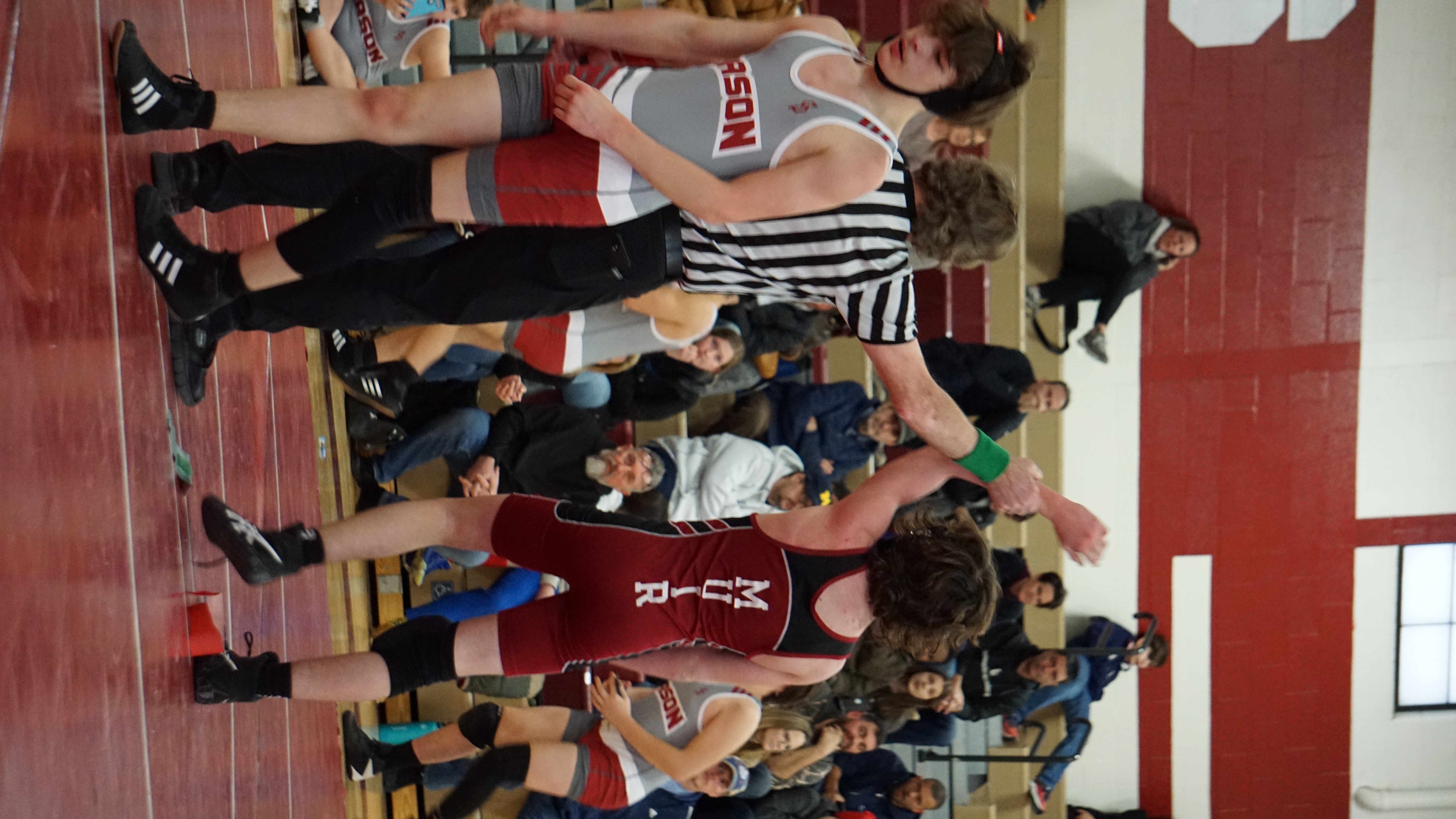 Wrestler's arm held up by referee signifying victory