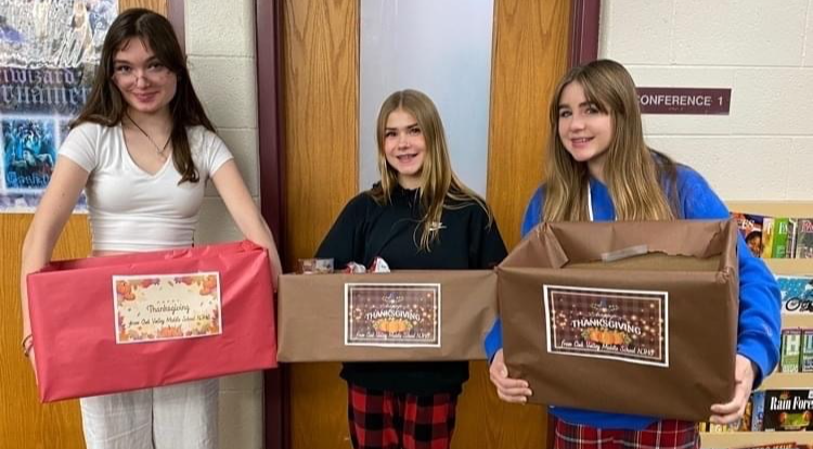 students holding Thanksgivng baskets of food