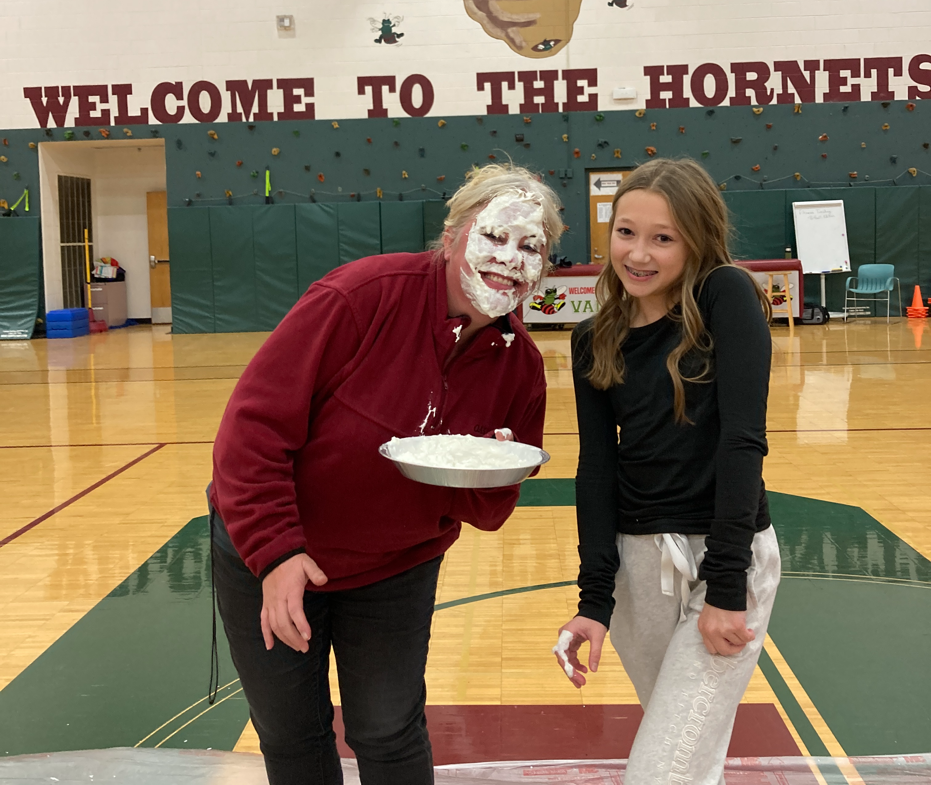 girl and a teacher with pie in the face