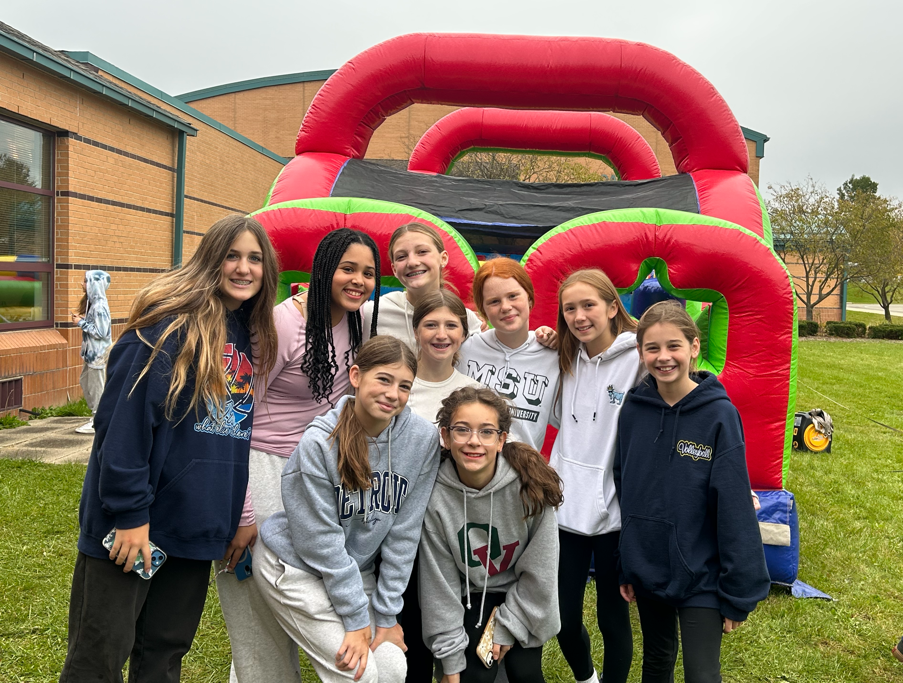 girls posing by inflatable obstacle course