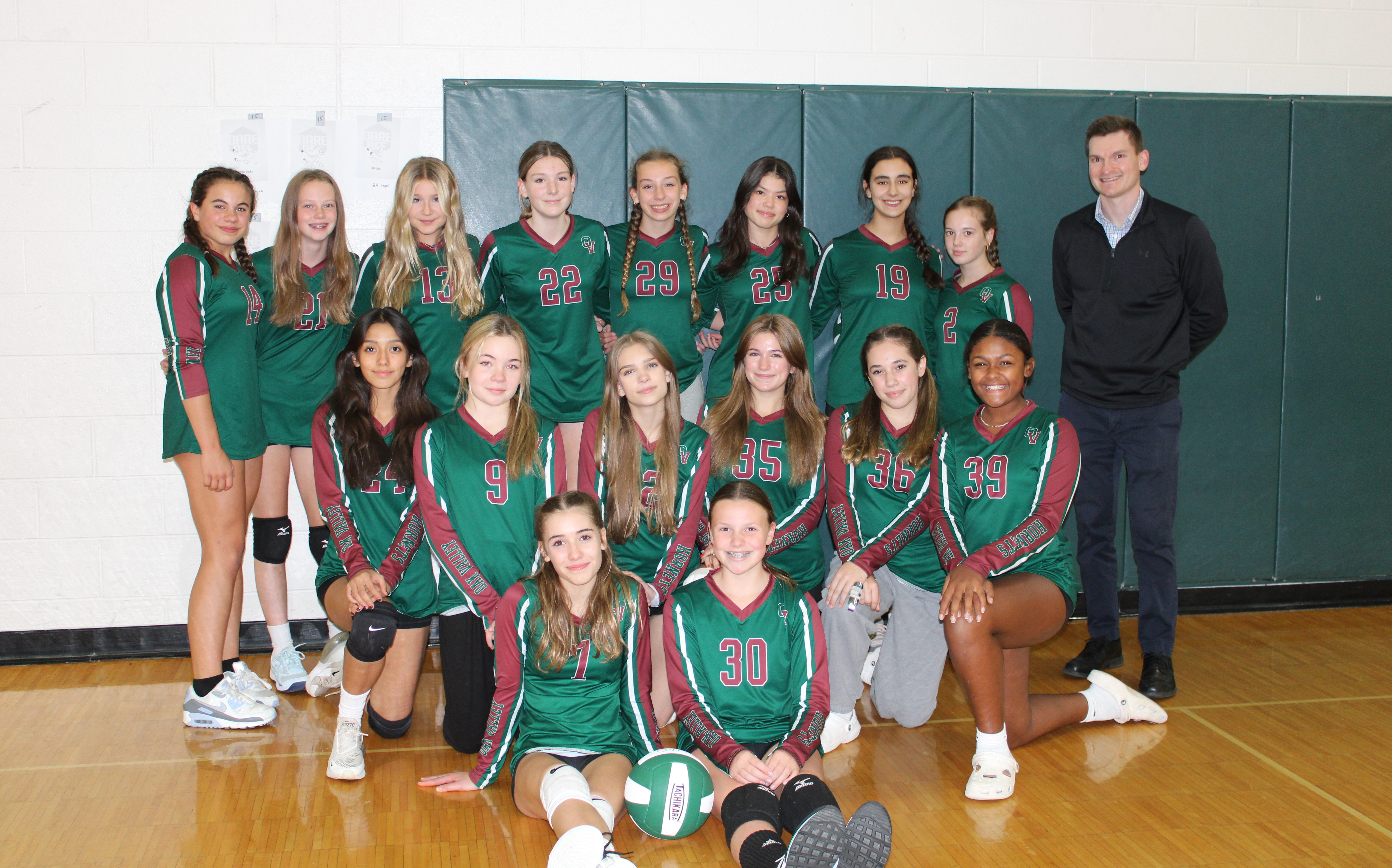 8th grade volleyball team poses together
