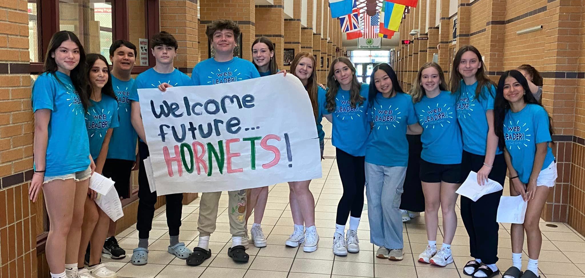 students hold sign to welcome new students