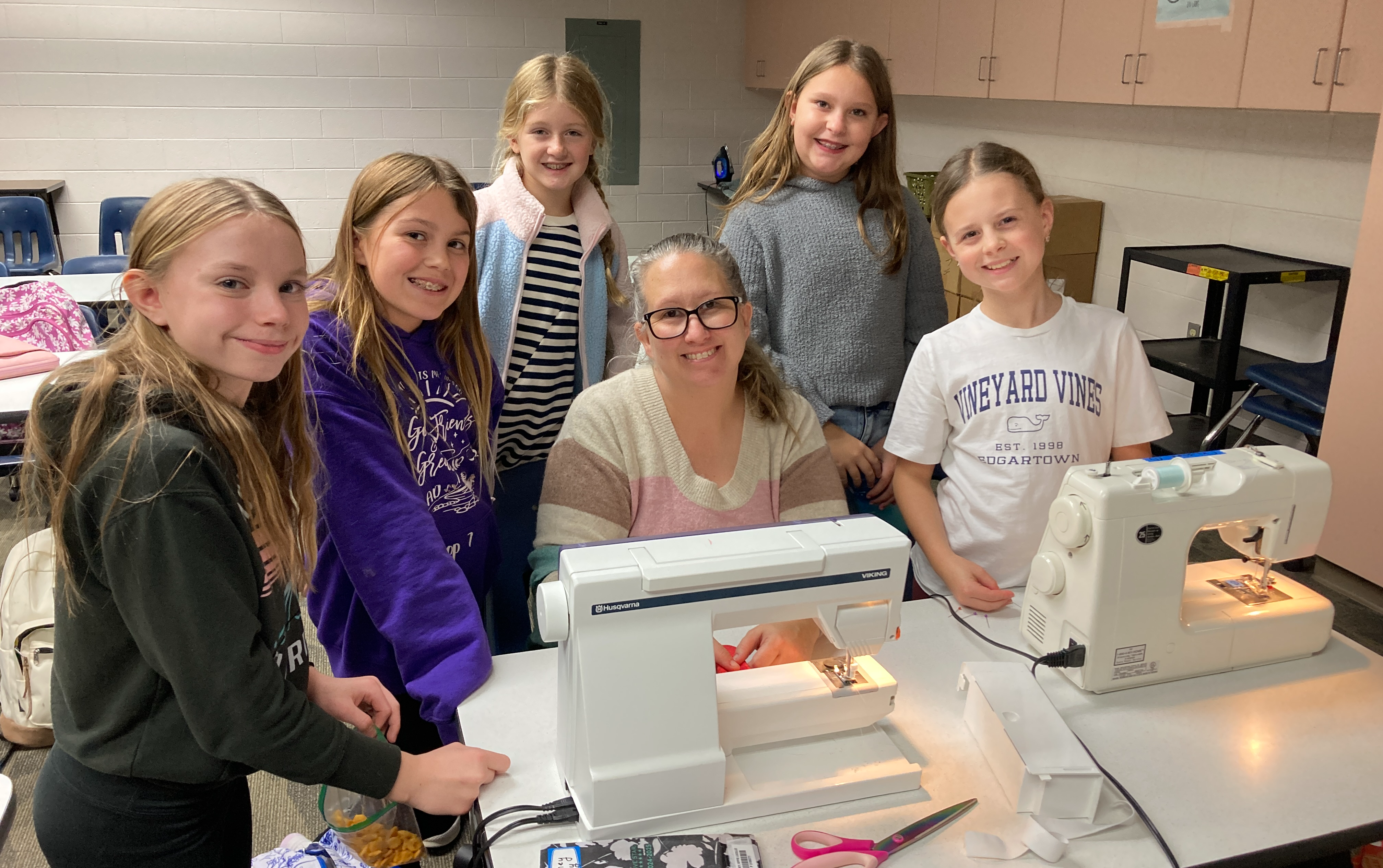 sewing club poses by machine