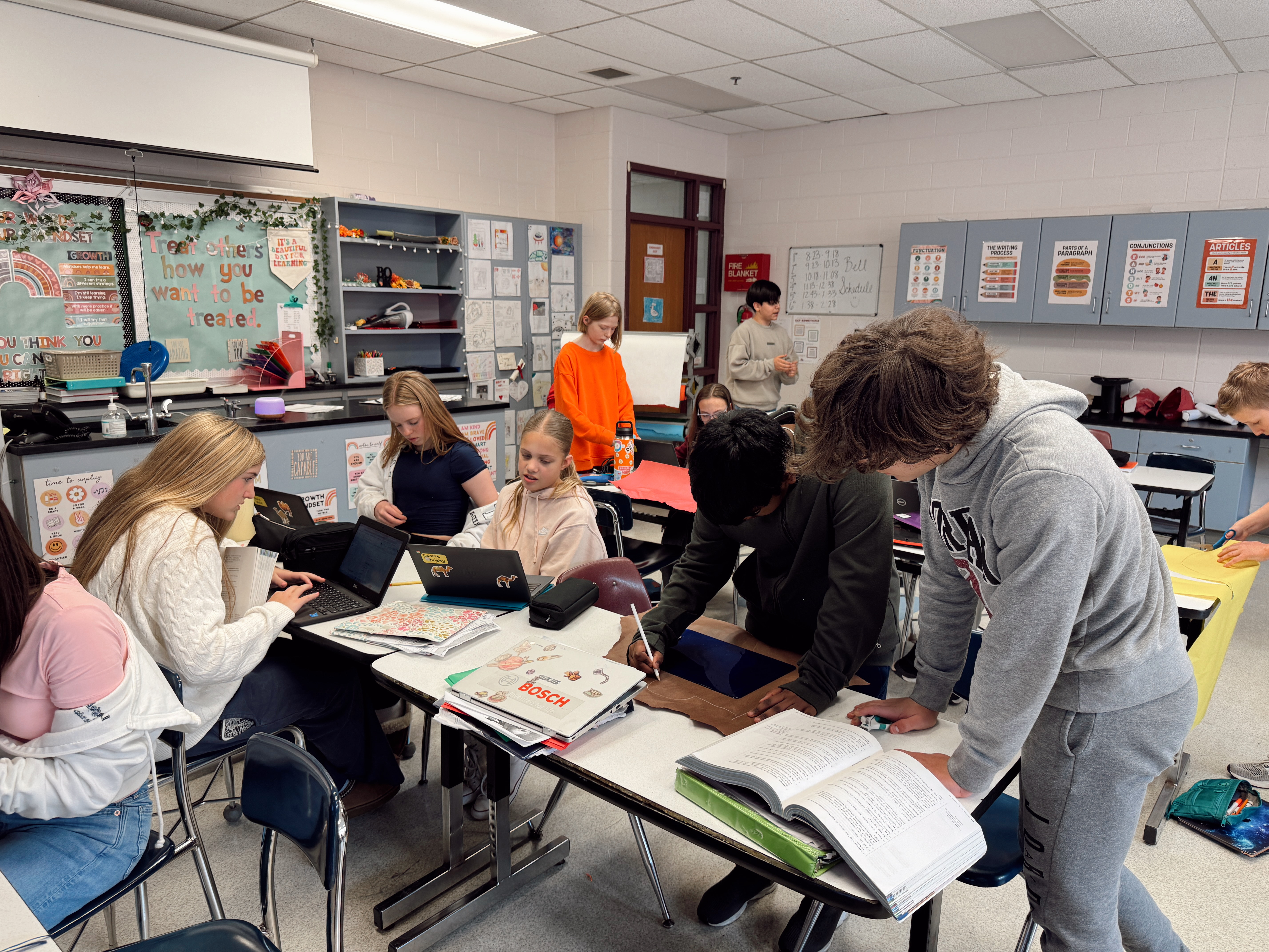7th grade students using construction paper to make props for an ELA project