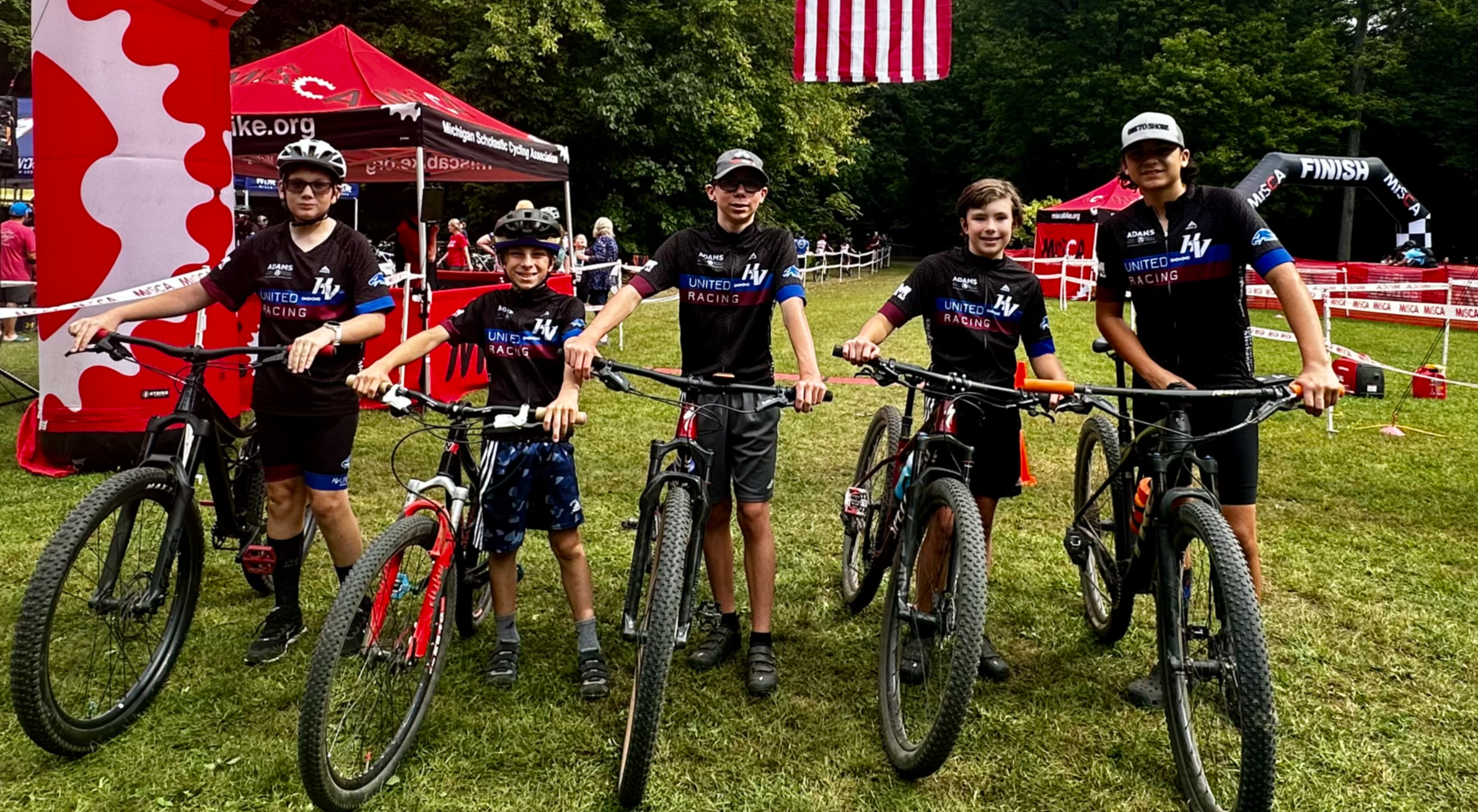 Five bike racers pose at starting line