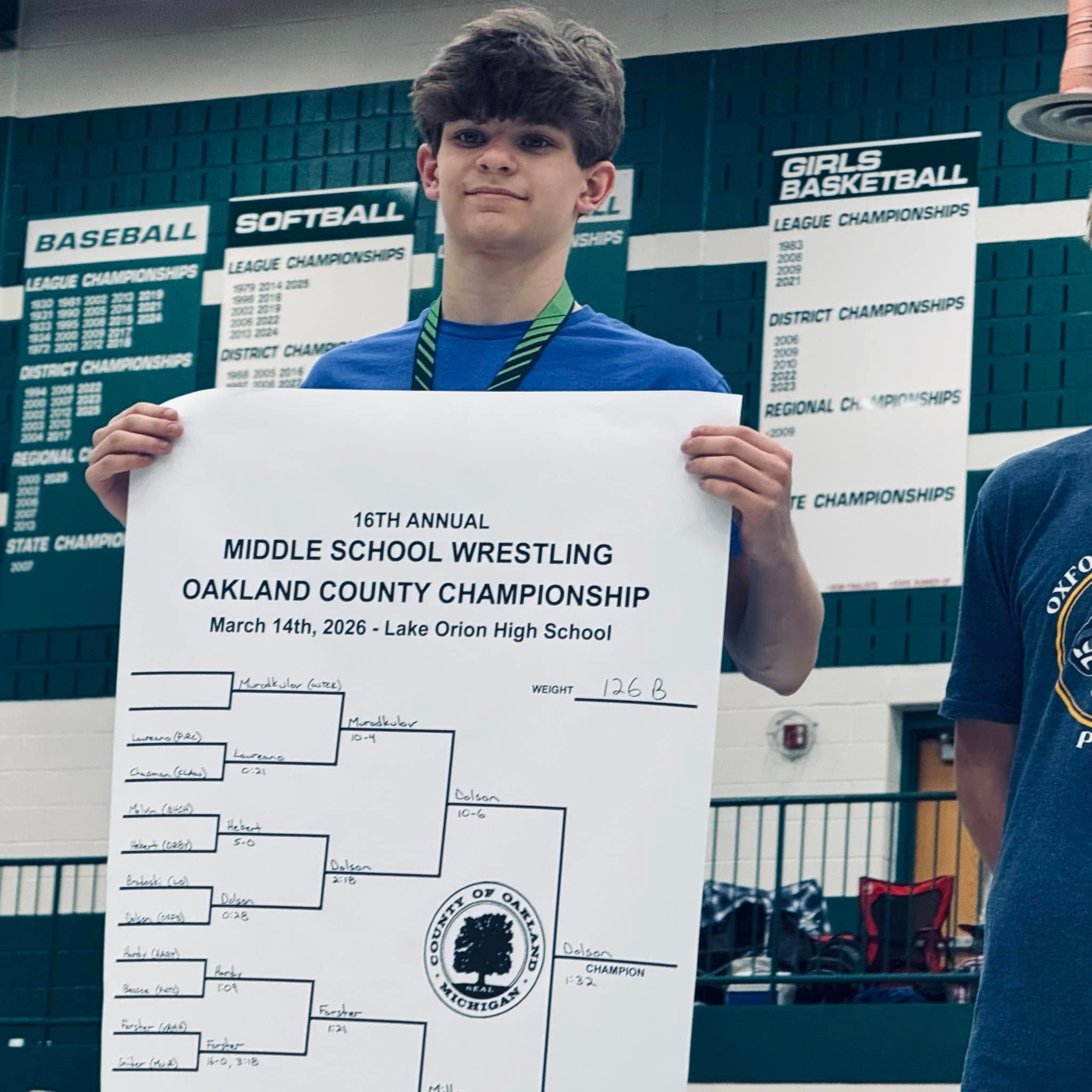 Wrestler holding up bracket sheet at event