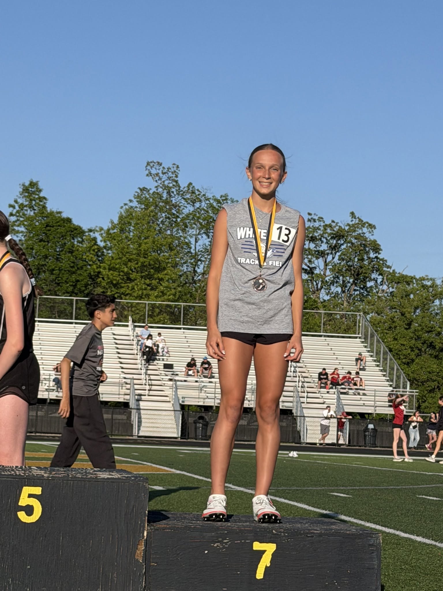 runner posing for a photo with medals around their neck