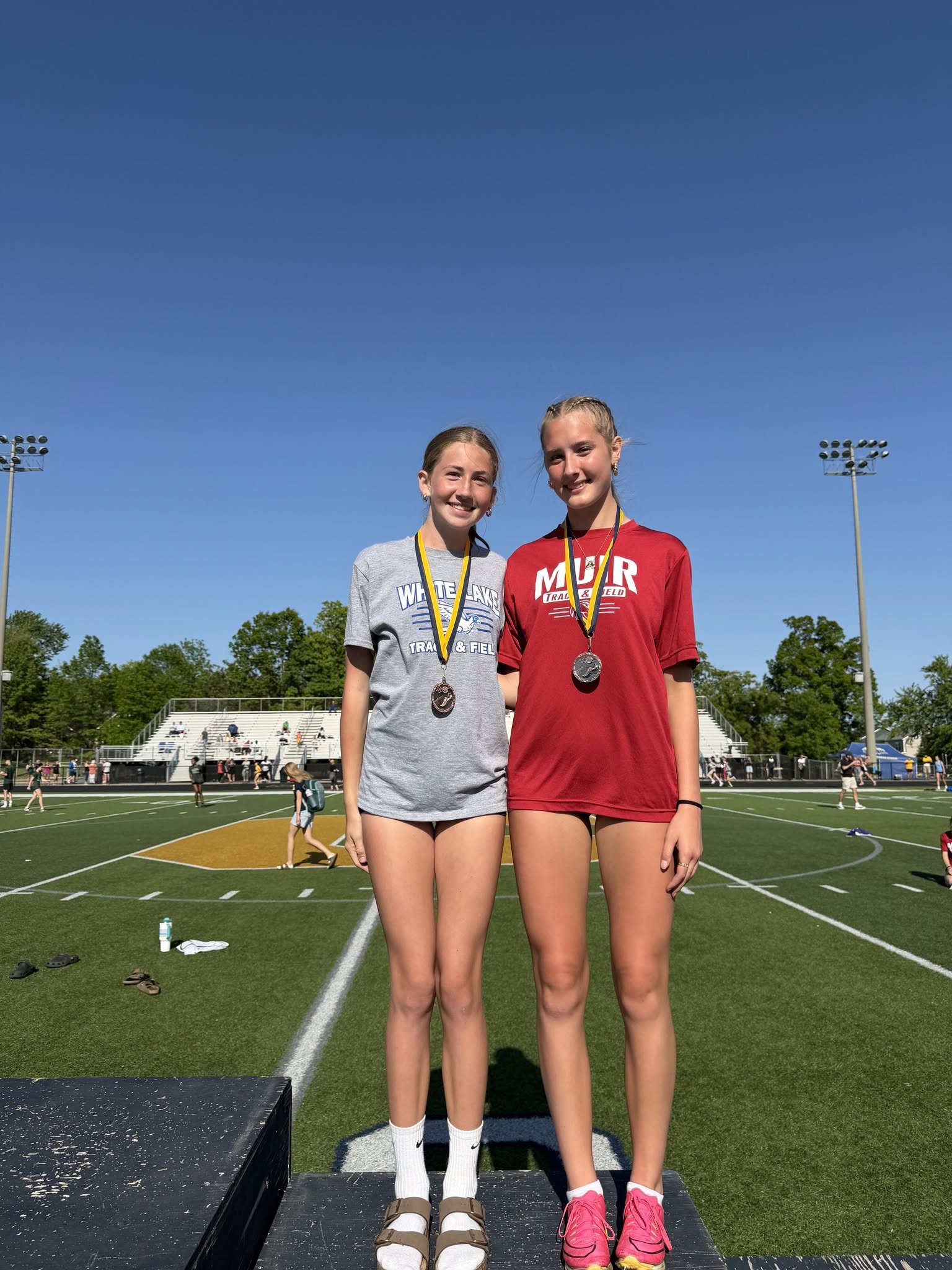 a pair of runners posing for a photo with medals around their necks